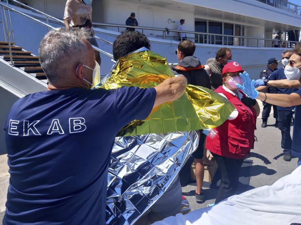 Survivors receive first aid after a rescue operation at the port in Kalamata town, about 240 kilometers (150miles) southwest of Athens on Wednesday, June 14, 2023. Authorities say at least 3o people have died after a fishing boat carrying dozens of migrants capsized and sank off the southern coast of Greece. A large search and rescue operation is underway. Authorities said 104 people have been rescued so far following the incident early Wednesday some 75 kilometers (46 miles) southwest of Greece’s southern Peloponnese region.(www.argolikeseidhseis.gr via AP)