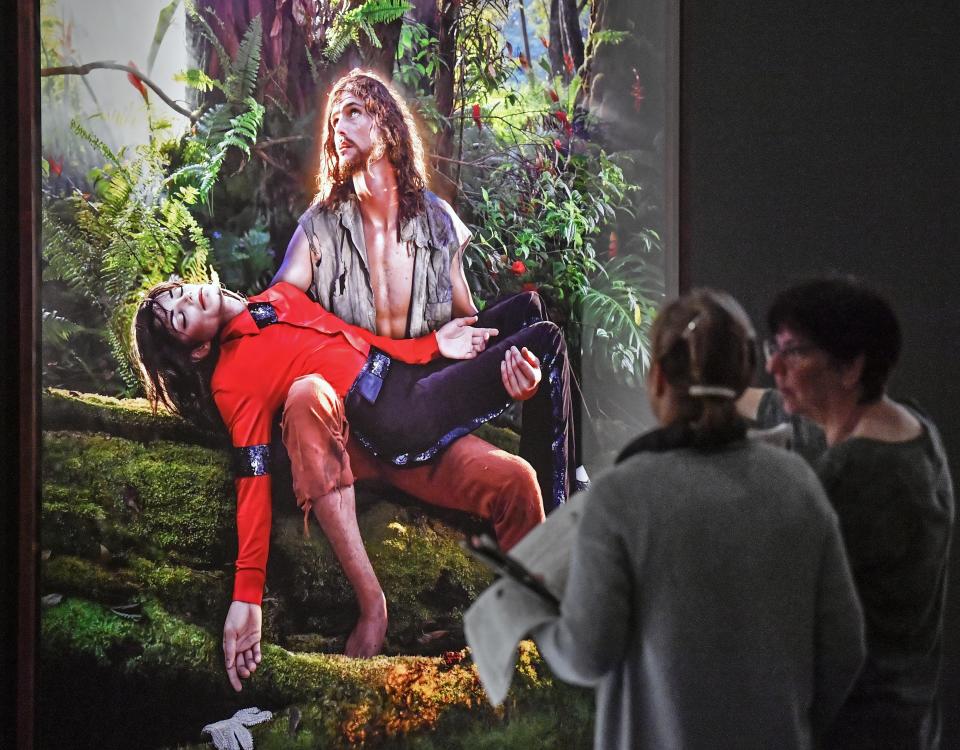 Visitors talk about the picture 'American Jesus: Hold me, carry me boldly' from US artist David LaChapelle at a preview of the exhibition 'Michael Jackson: On The Wall' at the Bundeskunsthalle museum in Bonn, Germany, Thursday, March 21, 2019. The exhibition around the controversial iconic pop idol is open until July 14. (AP Photo/Martin Meissner)