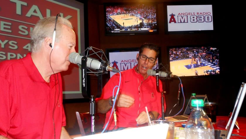 Broadcasters Terry Smith, left, and Victor Rojas talk to fans during a call-in show on 830 AM.