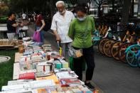 People look at books displayed at a street stall at the Sanlitun shopping area in Beijing