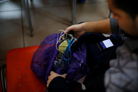 A deportee open a bag with his belongings at an immigration facility after a flight carrying illegal immigrants from the U.S. arrived in San Salvador, El Salvador, January 11, 2018. Picture taken January 11, 2018. REUTERS/Jose Cabezas