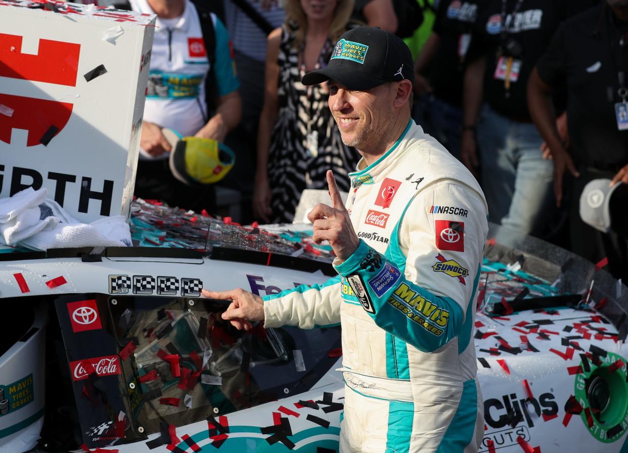 Denny Hamlin (11) applies the winner’s sticker to his car in victory lane after winning the Würth 400, Sunday at Dover Motor Speedway.