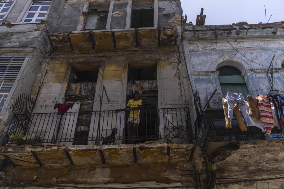 Anet Ayala y su perro miran desde su balcón en La Habana, Cuba, el lunes 13 de junio de 2022. (AP Foto/Ramón Espinosa)