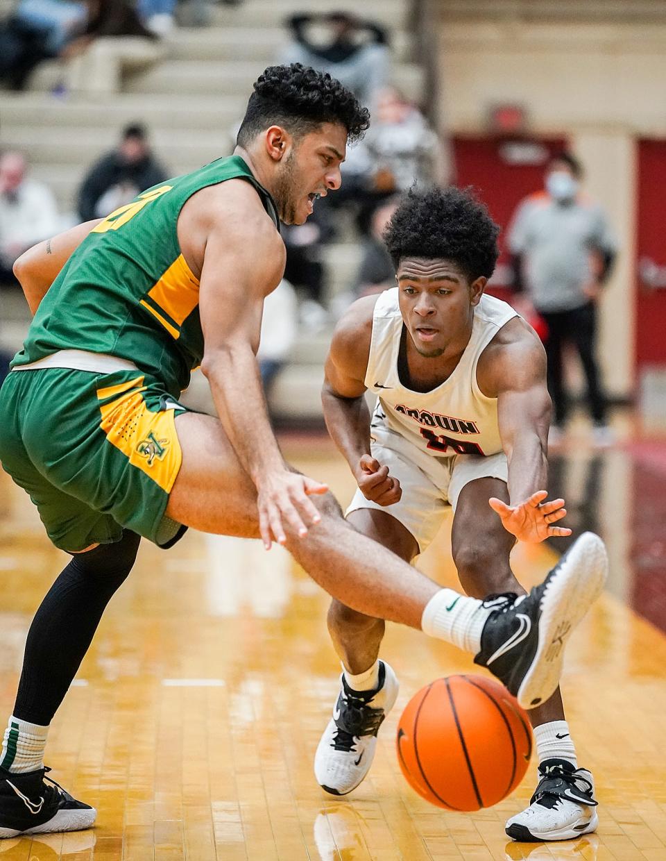 Brown's Kino Lilly Jr. passes the ball around Vermont's Justin Mazzulla in the second half.