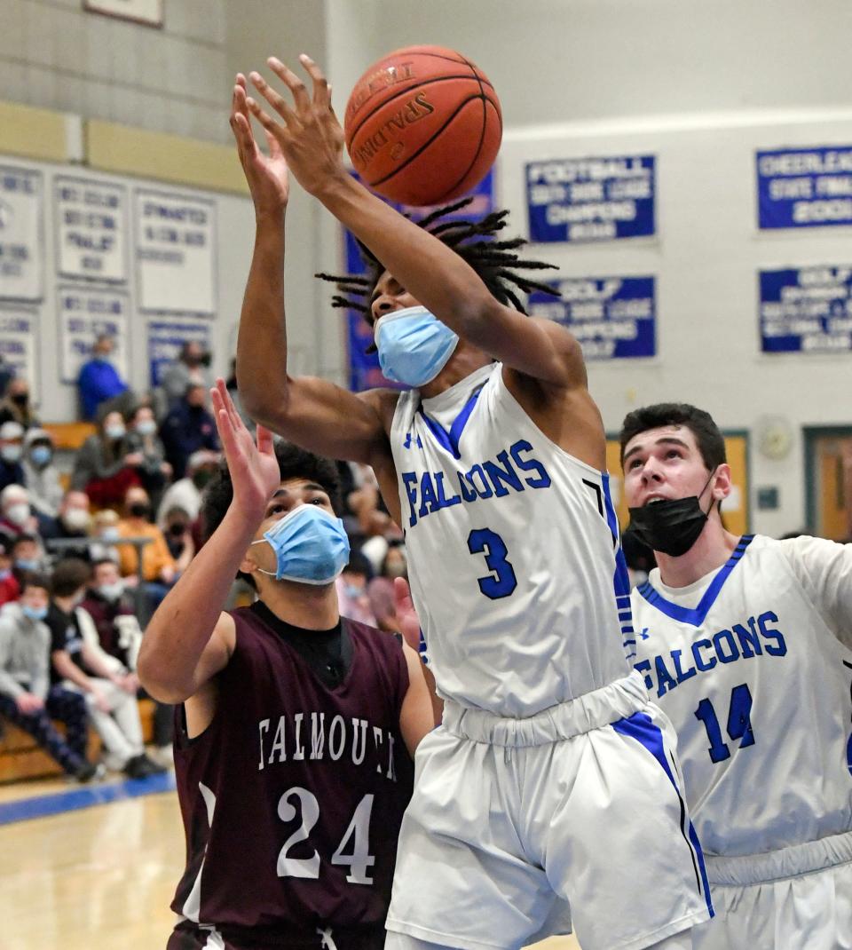 Otis Longman (3) and Sean Fancher of Mashpee and Jayden Bernhardt of Falmouth reach for a loose ball in this December 2021 action.