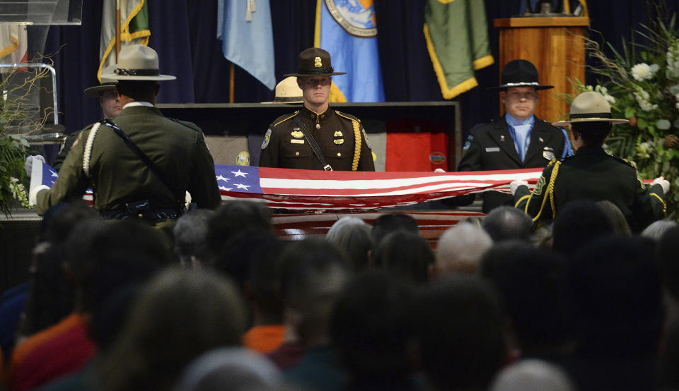 Honor guard members prepare to fold an American flag before presenting it to family members of Brian Hughes, a captain with the Arrowhead Interagency Hotshots who was killed by a falling tree while fighting the Ferguson Fire, during a memorial service at Valdez Hall in Fresno, Calif., Saturday, Aug. 4, 2018. (Craig Kohlruss /The Fresno Bee via AP)