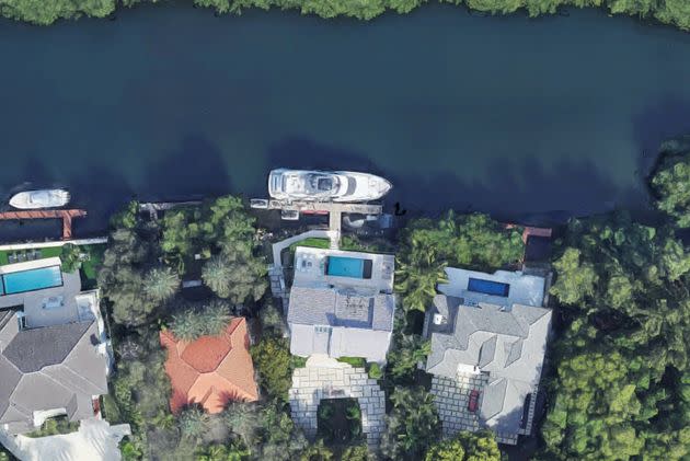 Sergio Pino was found dead in an early-morning raid at his $8 million waterfront mansion (pictured, center, with his yacht docked outside).