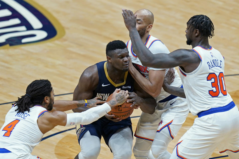 New Orleans Pelicans forward Zion Williamson is stopped by New York Knicks guard Derrick Rose (4), forward Julius Randle (30) and center Taj Gibson as he goes to the basket in the second half of an NBA basketball game in New Orleans, Wednesday, April 14, 2021. (AP Photo/Gerald Herbert)