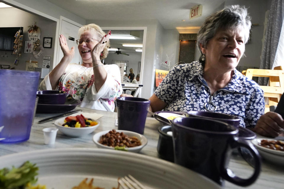 Debbie LaBarre, left, laughs while having breakfast, as part of the Meals on Wheels "Dine Out Club", with her sister, Suzanne Marchand, right, at the White Birch Cafe, Wednesday, Aug. 16, 2023, in Goffstown, N.H. In some states, programs that give struggling restaurants some of the federal and state money set aside to feed seniors have grown in popularity. The restaurants can provide balanced meals with more choices, flexible timing and a judgment-free setting that can help seniors get together to chat and stem loneliness. (AP Photo/Charles Krupa)