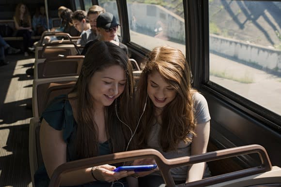 Two commuters listen to streaming music.