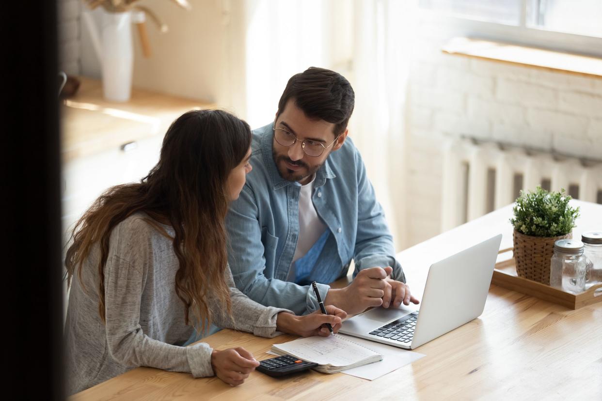 focused family couple discussing monthly expenses, calculating utility bills, mandatory payments, rent charges, sitting together at home