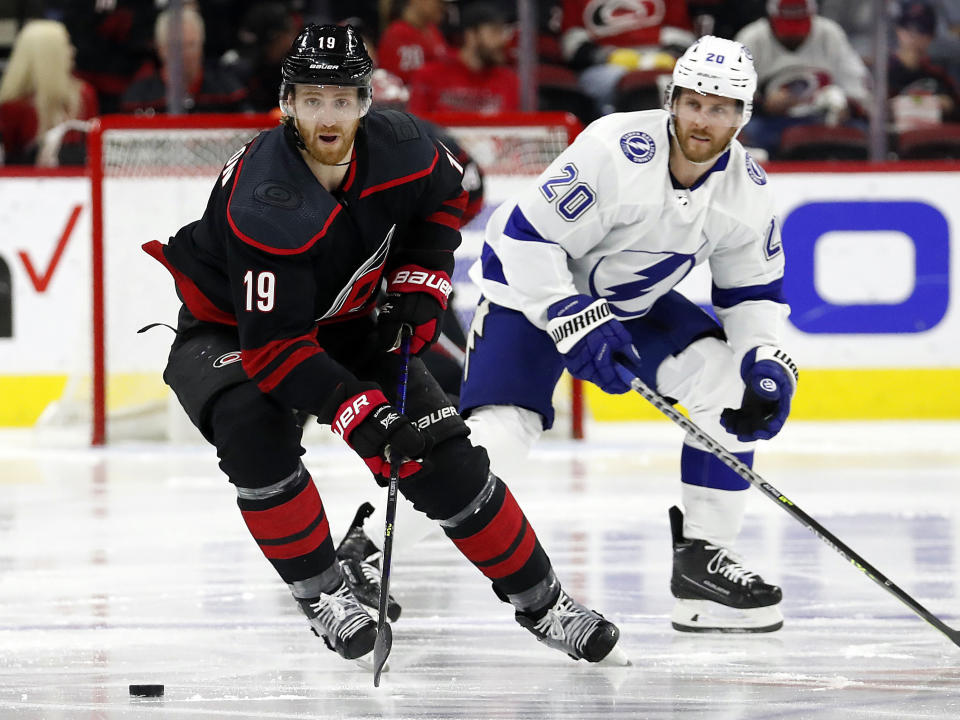 FILE - In this June 1, 2021, file photo, Carolina Hurricanes' Dougie Hamilton (19) moves the puck away from Tampa Bay Lightning's Blake Coleman (20) during the second period of Game 2 of an NHL hockey Stanley Cup second-round playoff series in Raleigh, N.C. After missing the playoffs the past three seasons, the New Jersey Devils are telling their fans this is going to be the year. They made several moves in the offseason to strengthen one the NHL's youngest teams. They signed defenseman Hamilton to a $63 million contract. (AP Photo/Karl B DeBlaker, File)