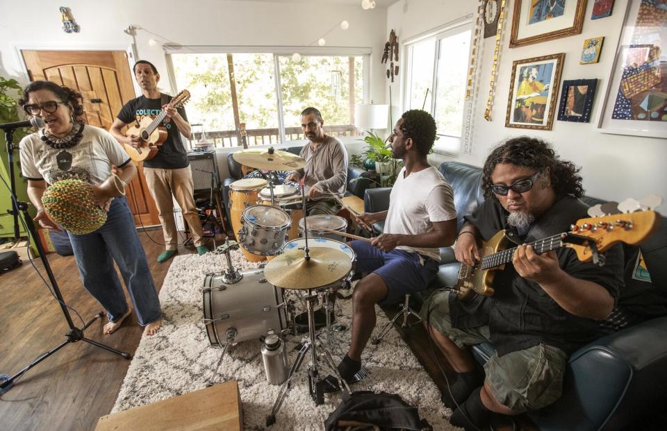 Musicians practice in a light-filled room.