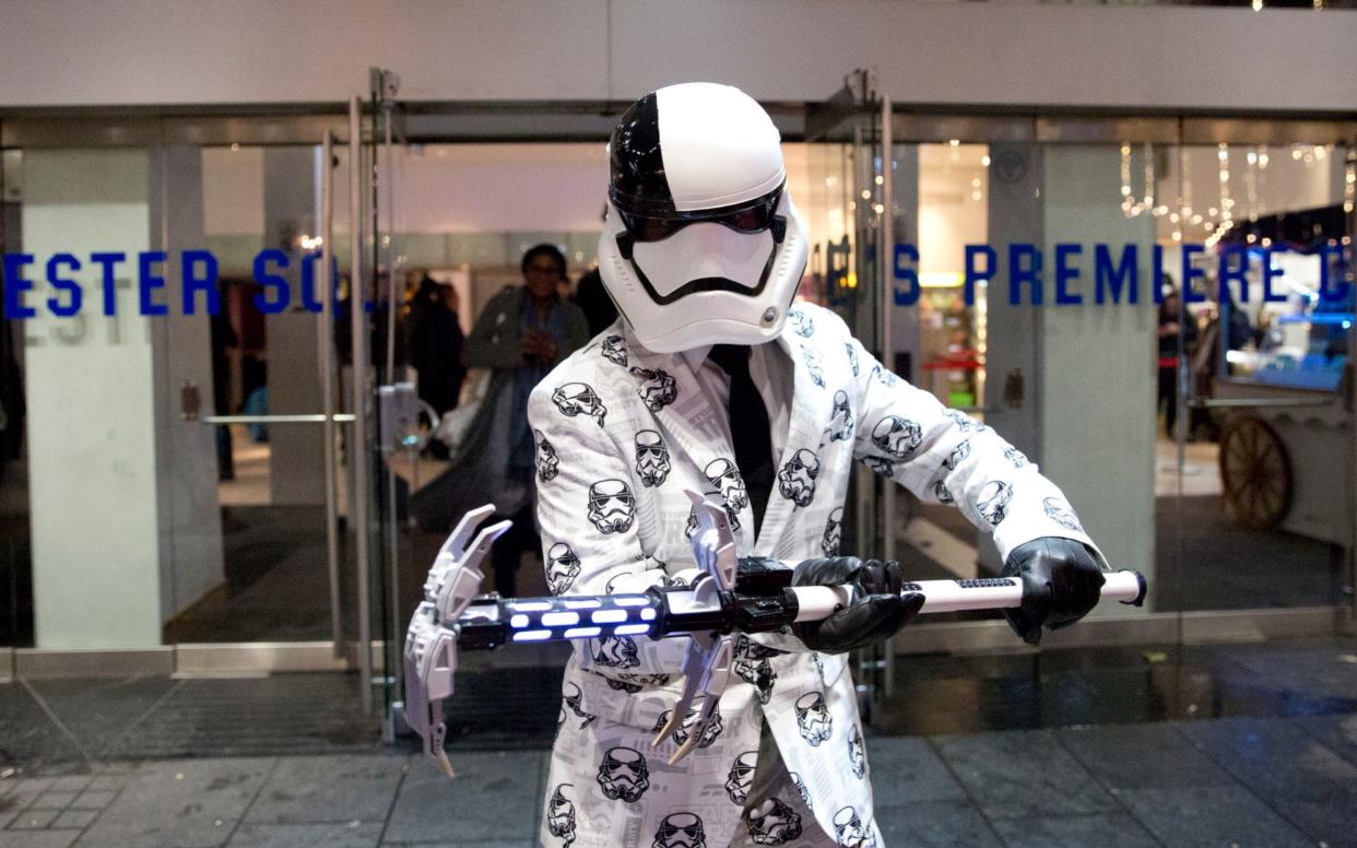 A Star Wars fan leaves a screening of Star Wars: The Last Jedi in Leicester Square. The films have helped boost the UK economy - PA