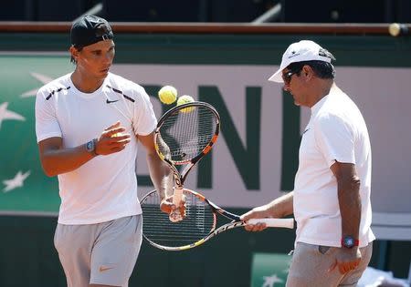 Rafael Nadal of Spain and his coach Toni Nadal (R) attend a training session for the French Open tennis tournament at the Roland Garros stadium in Paris, France, May 22, 2015. REUTERS/Vincent Kessler