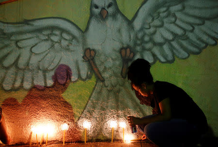 A woman lights a candle to pays respect during a vigil for victims of a collapsed tailings dam owned by Brazilian mining company Vale SA, in Brumadinho, Brazil January 31, 2019. REUTERS/Adriano Machado