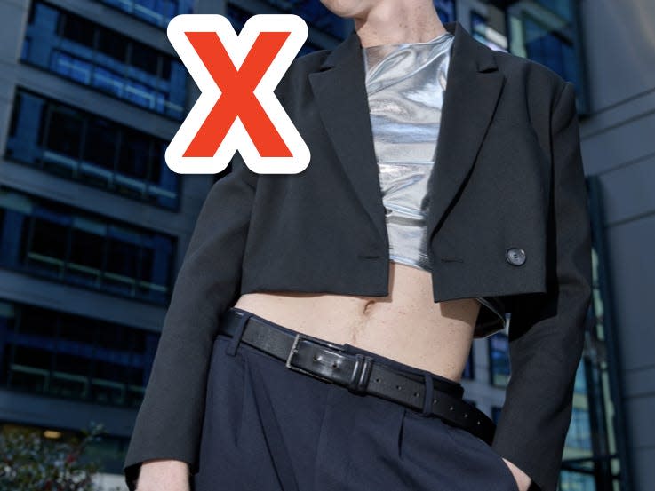 red x over person wearing black cropped blazer over a shiny silver top