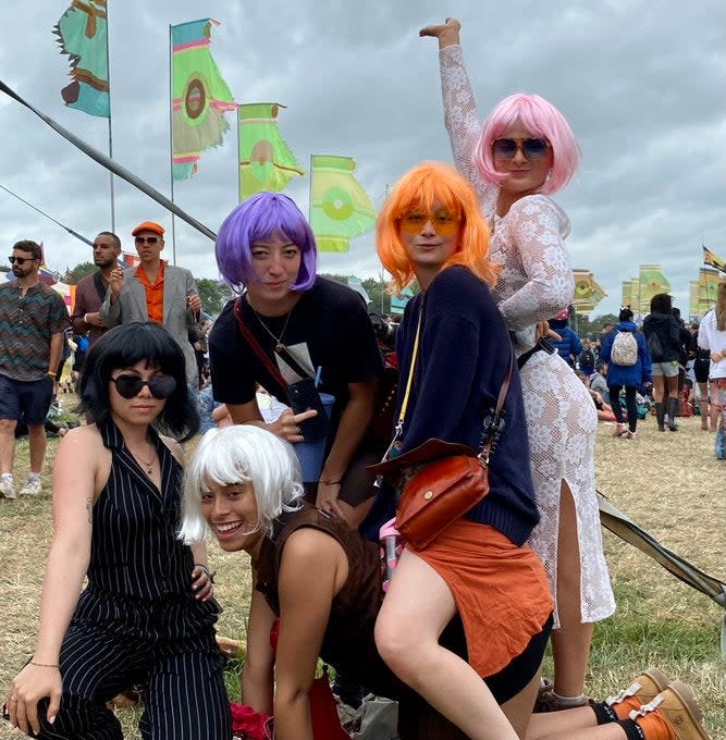 Festival-goers pose in bright wigs (Twitter @GlastoLive)