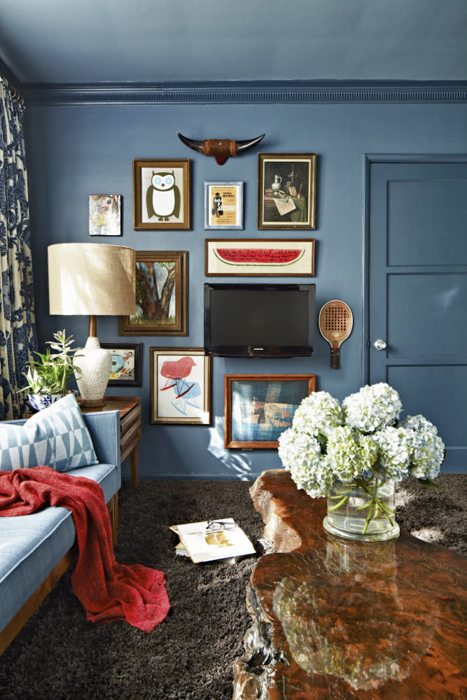 This publicity photo provided by Brian Patrick Flynn shows a living room by designer Brian Patrick Flynn, with art on the walls bought second-hand at flea markets for this Southern California weekend home. The whimsical mix of paintings and prints provides a perfect spot to hide a flat-screen television. (AP Photo/Brian Patrick Flynn, Daniel Collopy)