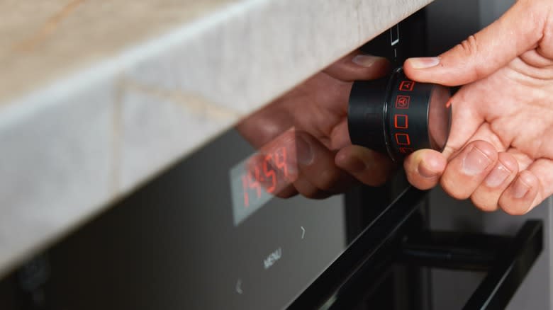 Hand adjusting oven heat timer