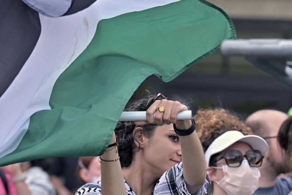 A demonstrator waves a Palestinian flag, Monday, May 6, 2024, in at MIT in Cambridge, Mass. after several hundred demonstrators tore down barricades and joined pro-Palestinian demonstrators that been given a deadline to leave the encampment. (AP Photo/Josh Reynolds)
