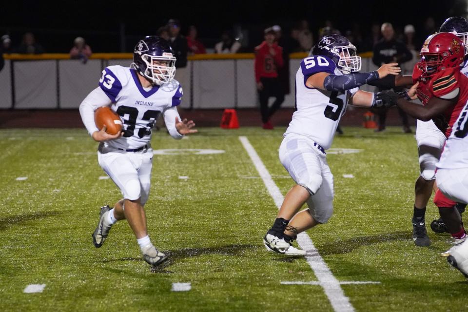 Mount Gilead's Garrett George runs the ball with the blocking of Nick Garvey Friday night in a Division VI, Region 23 playoff football game at Worthington Christian.