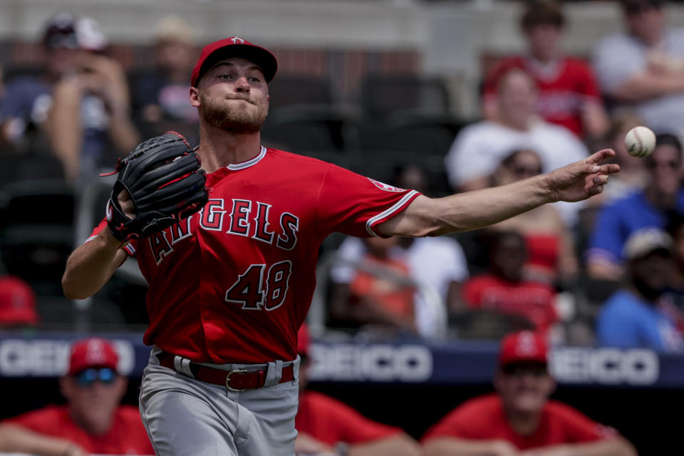 Los Angeles Angels starting pitcher Reid Detmers makes an errant throw to first on a hit by Atlanta Braves' Guillermo Heredia during the fifth inning of a baseball game Sunday, July 24, 2022, in Atlanta. (AP Photo/Butch Dill)