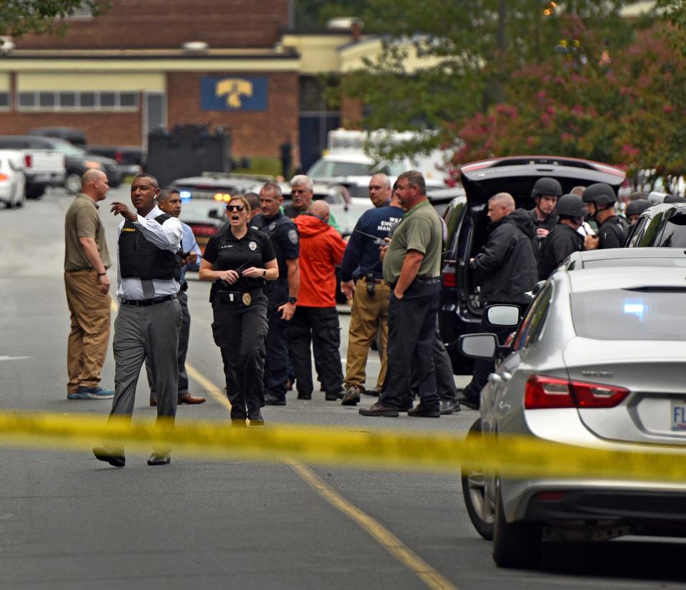 A Forsyth County Sheriff directs law enforcement officers on the scene at Mount Tabor High School Wednesday, Sept. 1, 2021 in Winston-Salem, N.C. Authorities say one student was killed in a shooting at a North Carolina high school and a suspect has been taken into custody.