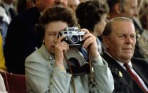<p>Although she is the most photographed woman in the world, the Queen has been a lifelong fan of photography. Here, she captures a photo with her camera at the Royal Windsor Horse Show in 1982.</p>