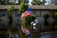 <p>A U.S. flag flies outside a flooded home in Bonita Springs, Fla., on Sept. 12, 2017. Hurricane Irma smashed into Southern Florida as a Category 4 storm, driving a wall of water and violent winds ashore and marking the first time since 1964 the U.S. was hit by back-to-back major hurricanes. (Photo: Daniel Acker/Bloomberg via Getty Images) </p>