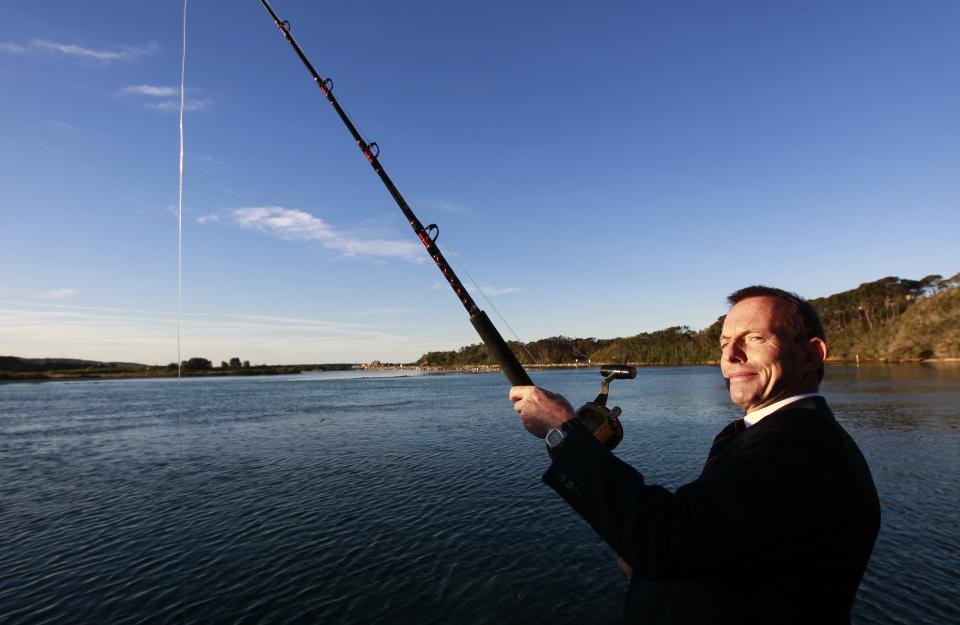 Opposition Leader Tony Abbott poses with a fishing rod during a visit to Narooma