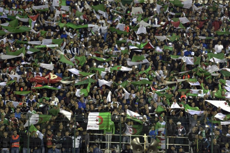 Algeria's supporters wave the country's flag during the FIFA World Cup 2018 qualifying football match between Algeria and Tanzania on November 17, 2015 in Blida