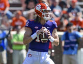 FILE - In this April 6, 2019, file photo, Clemson's Trevor Lawrence drops back to pass during Clemson's annual Orange and White NCAA college football spring scrimmage in Clemson, S.C. Clemson’s defense was a big reason why the Tigers won a second national championship in three seasons. Now that unit has massive holes to fill after losing its entire front to the NFL, along with three key linebackers and two members of the secondary _ and that could mean the Tigers have to win shootouts behind quarterback Trevor Lawrence to stay on top. (AP Photo/Richard Shiro, File)