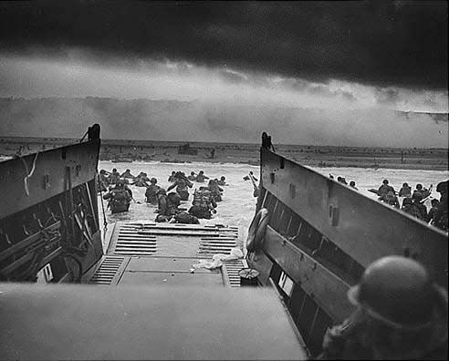 US soldiers wade through surf and German gunfire to secure a beachhead during the Allied Invasion on the beaches of Normandy on June 6, 1944