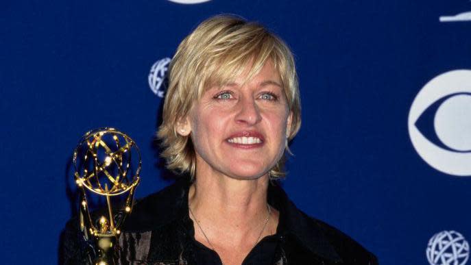 Ellen DeGeneres with her Emmy award, wearing a black shirt and black jacket