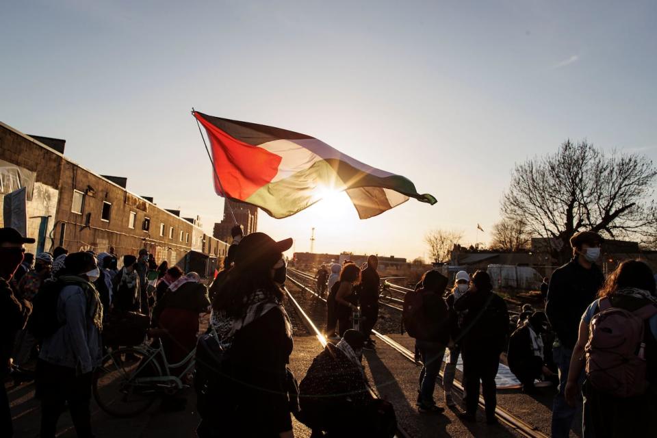 Protesters block a rail line in Toronto during a rally organized by World Beyond War on April 16, 2024.