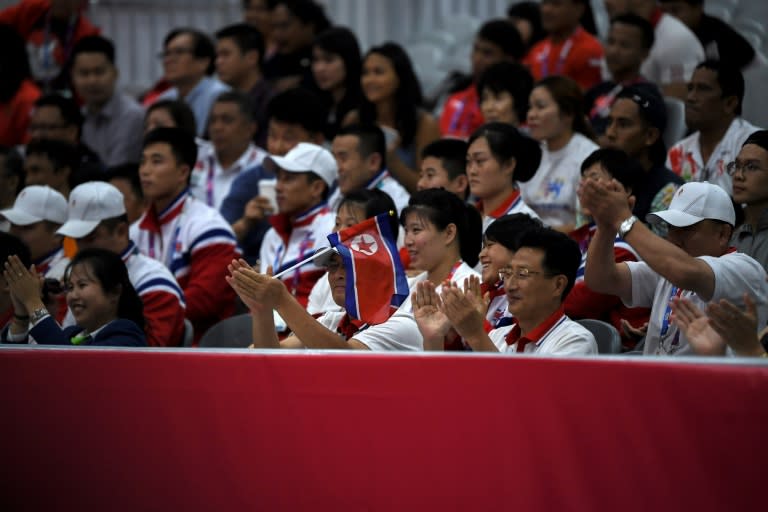 North Korean team members mingle with the public in the stands at the Jakarta International Expo during the Asian Games weightlifting