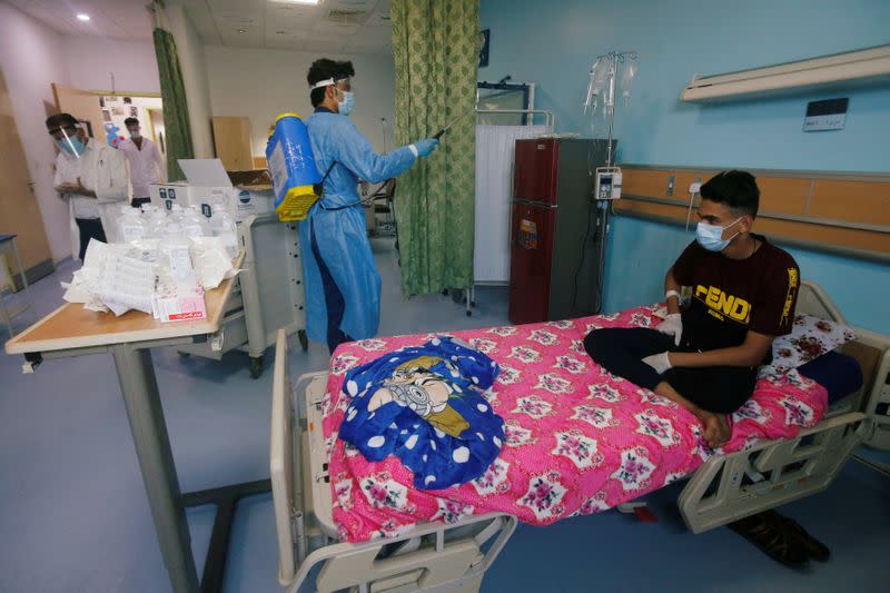 A worker wearing protective gear sprays disinfectant at the Children's Hospital for Cancer Diseases in Basra