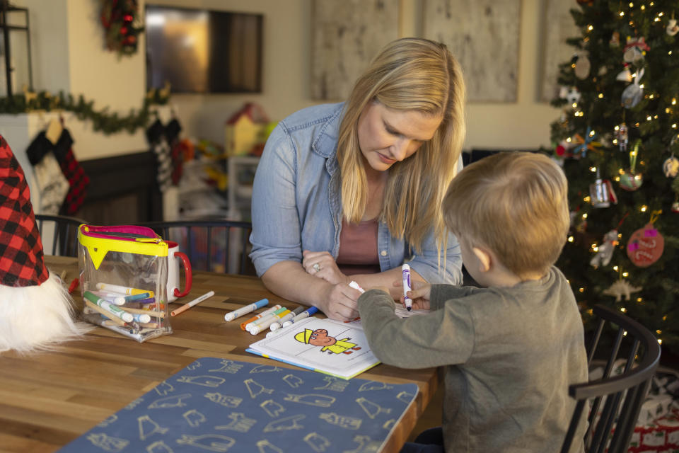 Kaitlyn Kash uses a coloring book with her 5-year-old son at home, Sunday, Dec. 17, 2023, in Austin, Texas. Kash has joined as a plaintiff on the Zurawski v. State of Texas case, a lawsuit that looks to clarify the scope of the state's abortion ban. (AP Photo/Stephen Spillman)