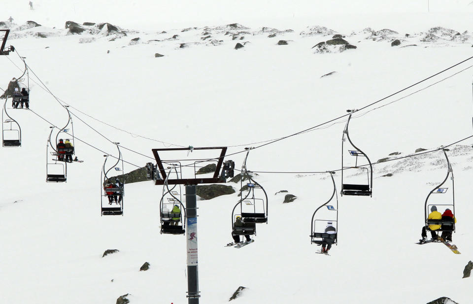 People travel in chairlifts, at the ski resort Porte Puymorens, in southwestern France, Saturday, June 1, 2013. The still-white slopes in the Pyrenees of southern France opened for business on Saturday, turning a cold damp spring into an rare June ski weekend. The Porte-Puymorens ski station opened Saturday morning at 8 a.m. for four hours in fog and light rain _ but plenty of snow with temperatures just above freezing. (AP Photo/Bob Edme)