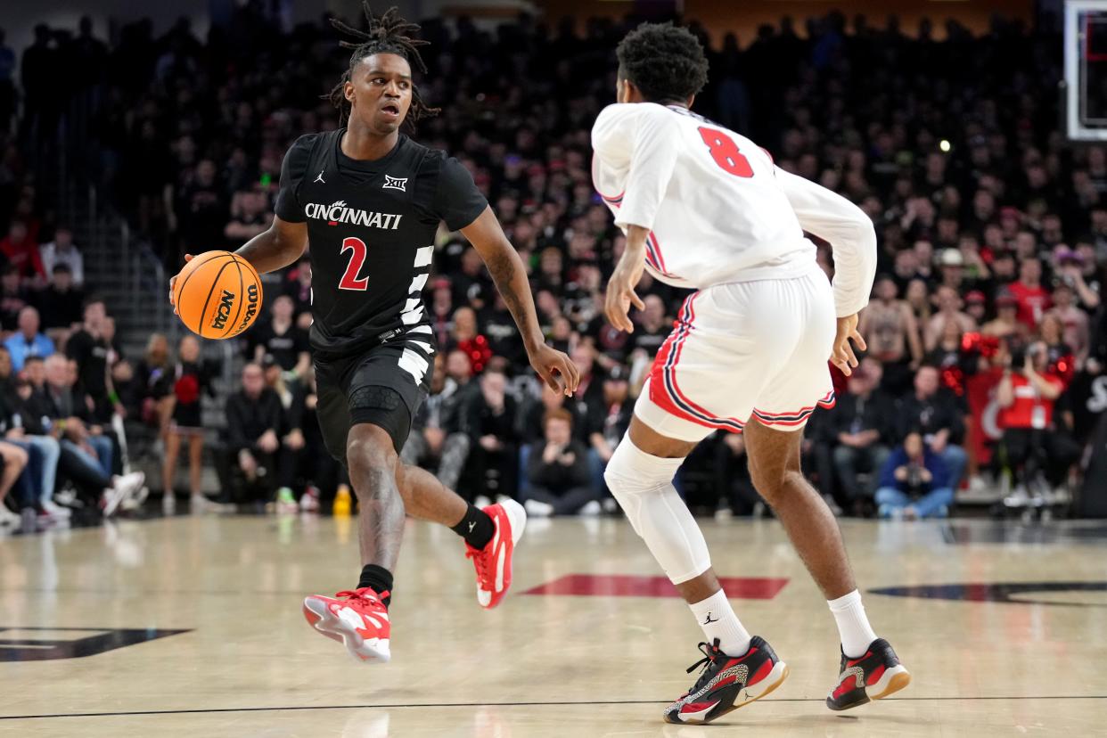 Cincinnati Bearcats guard Jizzle James (2) dribbles outside the 3-point line as Houston Cougars guard Mylik Wilson (8) defends in the first half of an NCAA college basketball game between the Houston Cougars and the Cincinnati Bearcats, Saturday, Feb. 10, 2024, at Fifth Third Arena in Cincinnati.