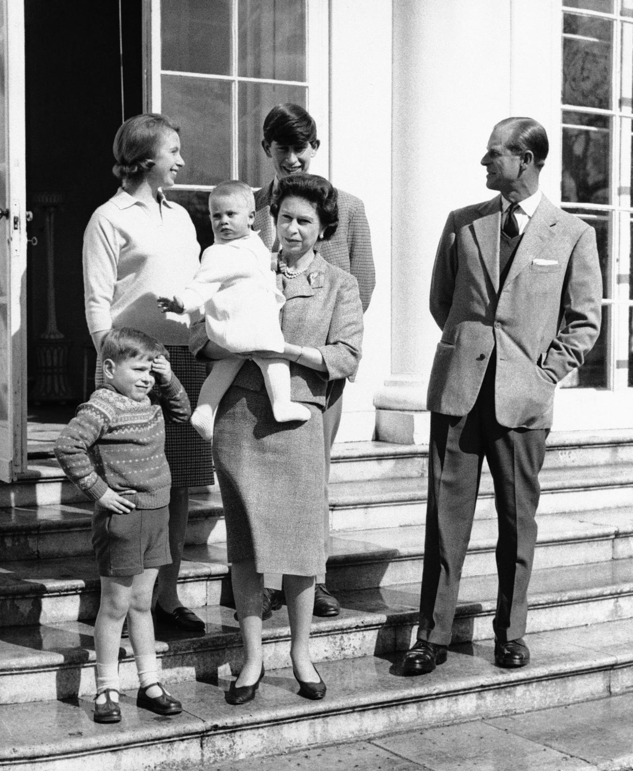 The royal British family is gathered on the steps of Frogmore House near Windsor, England, during a picture-taking session to mark Queen Elizabeth II 39th Birthday, April 21, 1965. The Queen holds Prince Edward, 1 while Prince Philip looks back at their two eldest, 1, while Prince Philip looks back at their two eldest Children, Princess Anne and Prince Charles. Prince Andrew, 4, finds the sun a little strong and shades his eyes. (AP Photo)