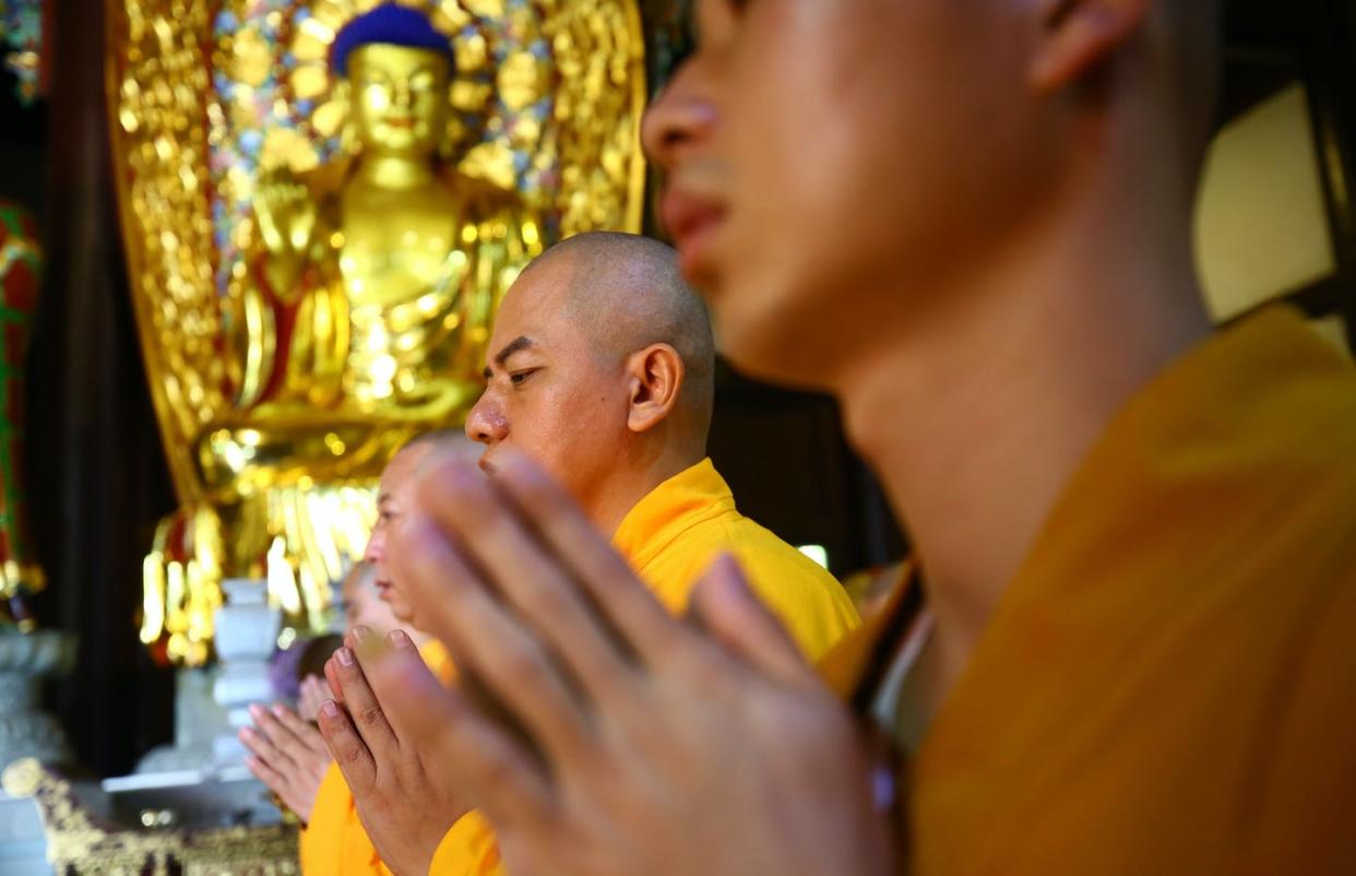 <span class="caption">Monks pray at Nanshan Temple in Sanya, Hainan Province of China.</span> <span class="attribution"><a class="link " href="https://www.gettyimages.com/detail/news-photo/monks-pray-during-ksitigarbha-bodhisattvas-birthday-news-photo/1272947130?adppopup=true" rel="nofollow noopener" target="_blank" data-ylk="slk:Chen Wenwu/VCG via Getty Images;elm:context_link;itc:0;sec:content-canvas">Chen Wenwu/VCG via Getty Images</a></span>