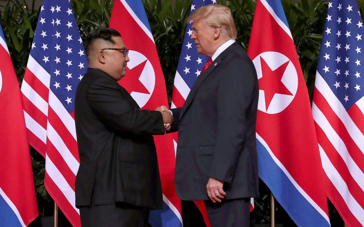 Kim Jong-un and President Donald Trump shake hands for the first time at the Singapore summit - REUTERS