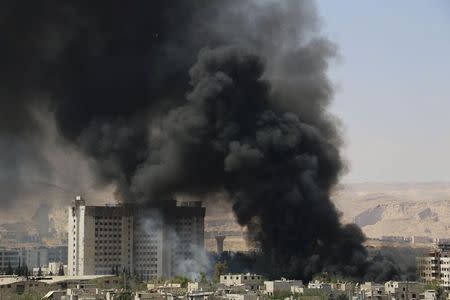 Smoke rises after what activists said were clashes between Al-Rahman corps and forces of Syria's President Bashar al-Assad in Al-Hajez garages, near the Damascus countryside governorate building at the southern entrance to Erbeen in the eastern Damascus suburb of Ghouta May 16, 2015. REUTERS/Amer Almohibany