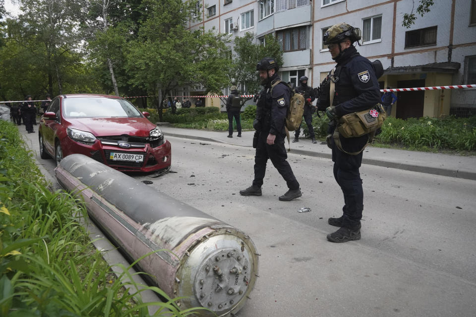 Police officers inspect part of a Russian missile that fell close to an apartment building in Kharkiv, Ukraine, Tuesday, May 14, 2024. (AP Photo/Andrii Marienko)