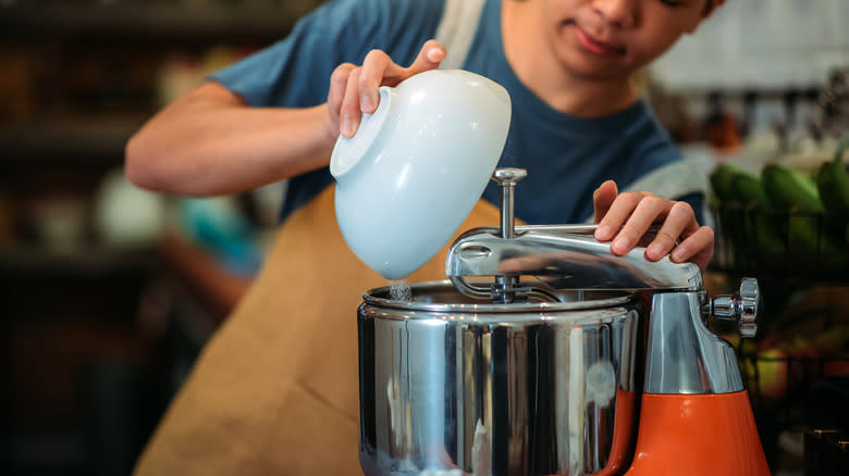 pouring ingredients into stand mixer