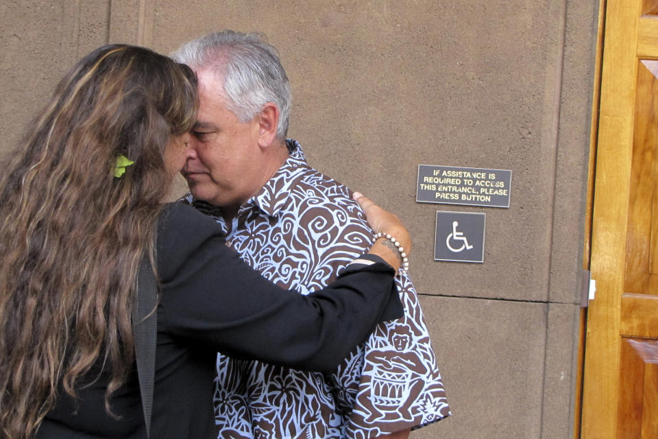 FILE - In this April 20, 2015, file photo Mike McCartney, center, Gov. David Ige's former chief of staff, greets Mauna Kea telescope opponent Kealoha Pisciotta using honi, a traditional Hawaiian forehead-to-forehead greeting at the Hawaii Capitol in Honolulu. People in Hawaii are changing how they express aloha in the time of coronavirus. Some residents say social distancing is the antithesis of tradition in the state, where people greet each other with hugs, kisses and lei, and families are close-knit. (AP Photo/Jennifer Sinco Kelleher, File)