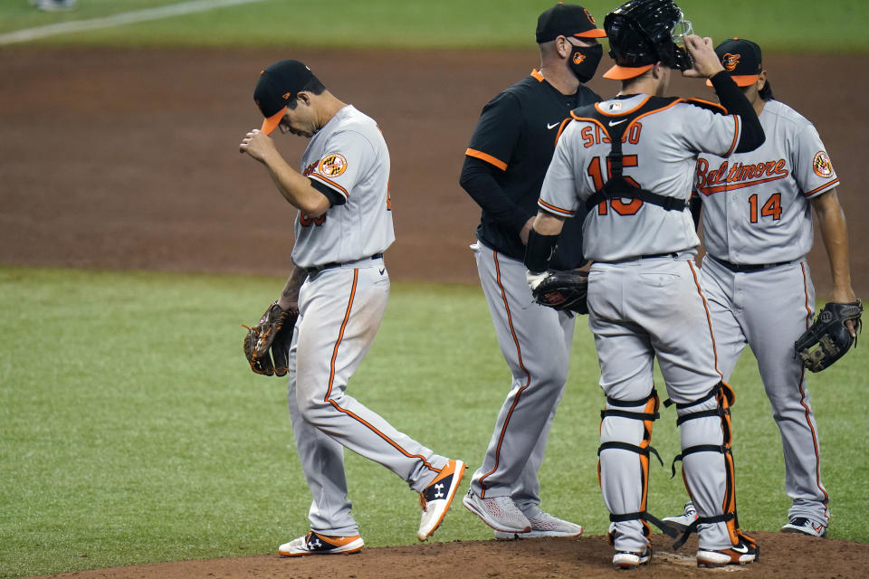 Baltimore Orioles starting pitcher Tommy Milone, left, reacts as he is taken out of the game against the Tampa Bay Rays during the sixth inning of a baseball game Tuesday, Aug. 25, 2020, in St. Petersburg, Fla. (AP Photo/Chris O'Meara)