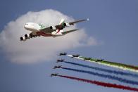 FILE - In this Nov. 17, 2019 file photo, an Emirates A-380 leads the "Al Fursan," or the Knights, UAE air force aerobatic display team during the opening day of the Dubai Airshow, in Dubai, United Arab Emirates. Dubai's government said Tuesday, March, 31, 2020, that it will inject equity into Emirates airlines as the Middle East's largest carrier has grounded nearly all of its flights at its hub due to the coronavirus restrictions on travel. Dubai's crown prince said in a statement on Tuesday that liquidity would be given to the state-owned airline, “considering its strategic importance” to Dubai and the economy of the United Arab Emirates. (AP Photo/Kamran Jebreili, File)